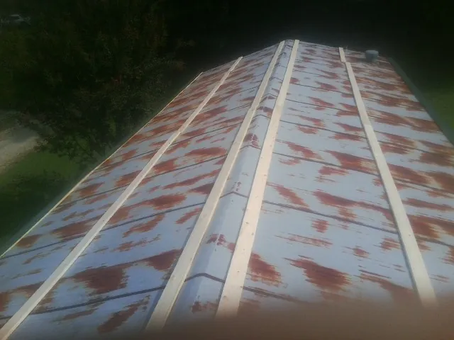 Rusted metal roof panels with new wood purlins before replacement — Storm Damage Roof Repair in White Oak by Roofing Brothers