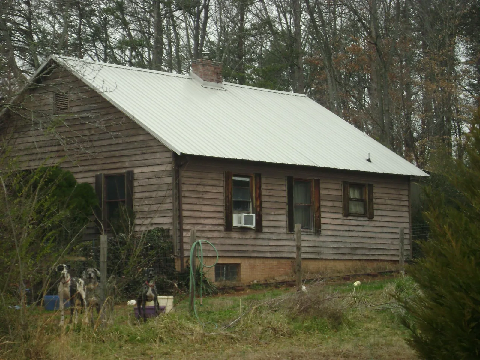 White metal roof on an old wood sided farmhouse, from a Metal Roof Installation job in White Oak